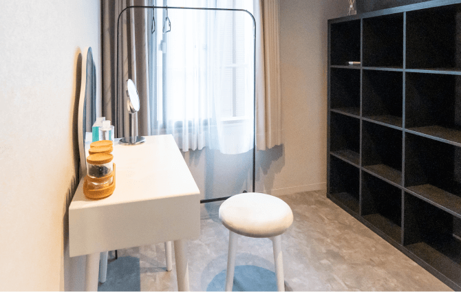 白い椅子と鏡台のある明るい清潔な部屋